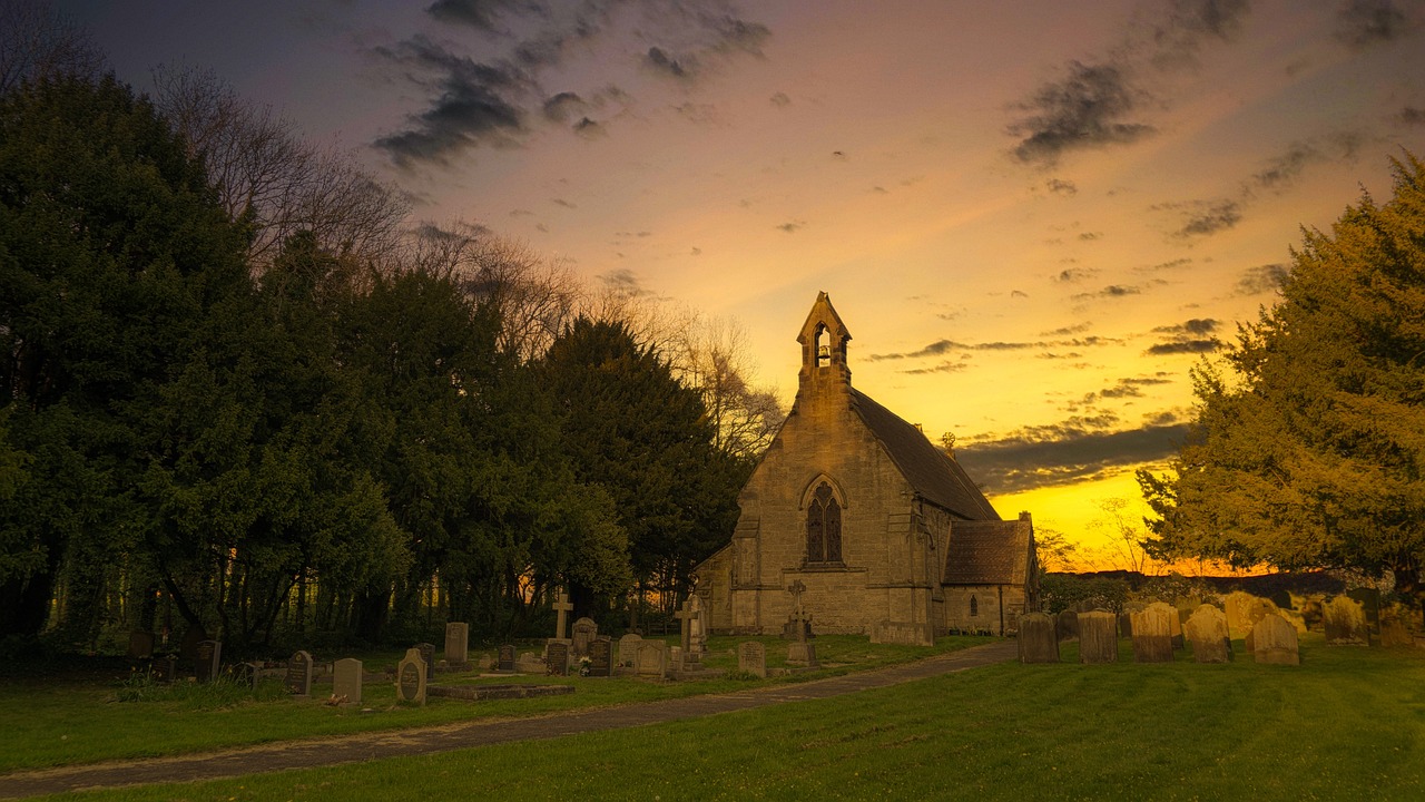 a church sitting on top of a lush green field, a picture, by Kev Walker, shutterstock, dappled golden sunset, graveyard landscape at night, shot with a canon 20mm lens, moderately detailed