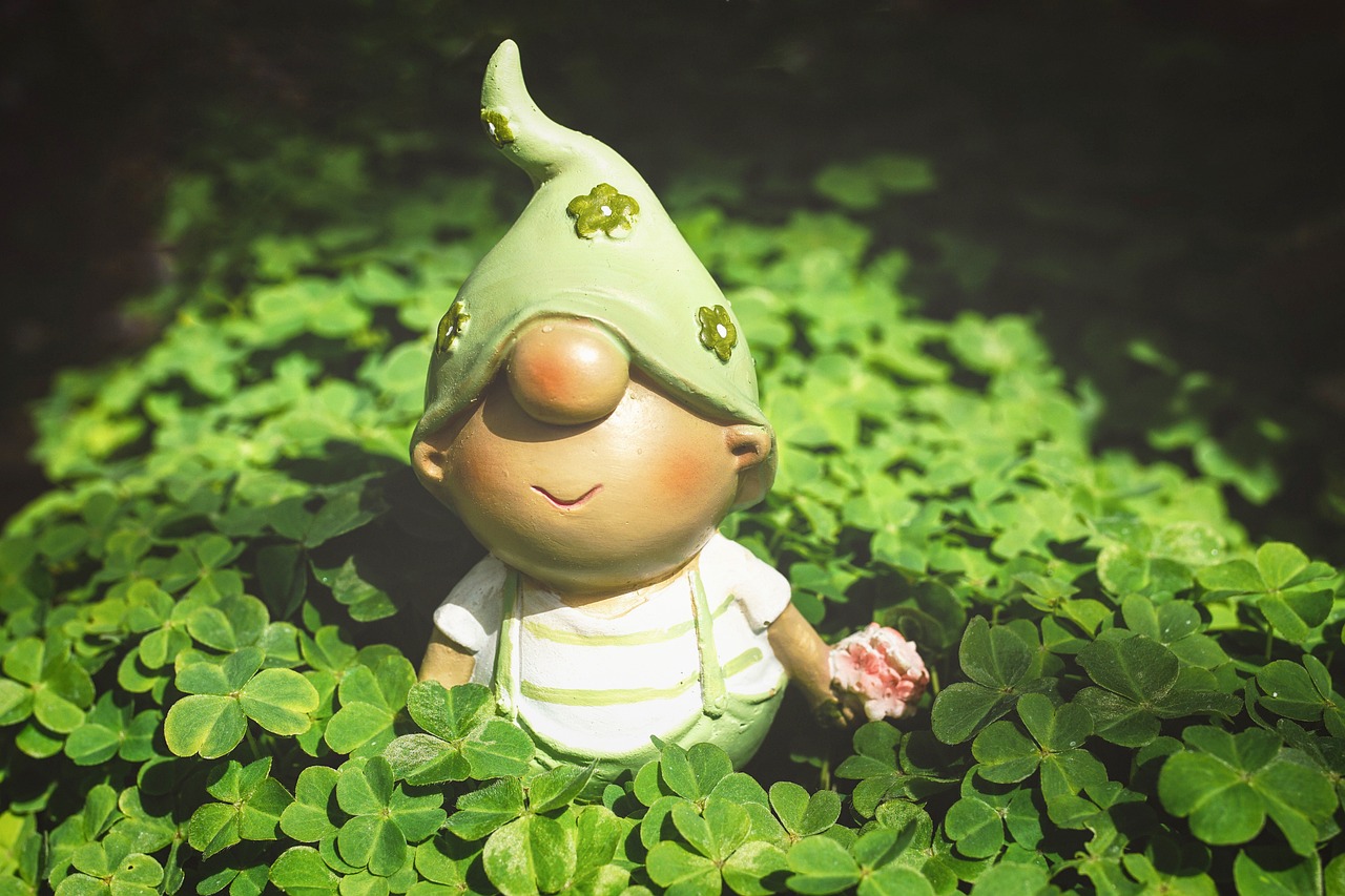 a small figurine sitting on top of a lush green field, pixabay contest winner, folk art, clover, portrait of an elf, cute nose, mobile wallpaper