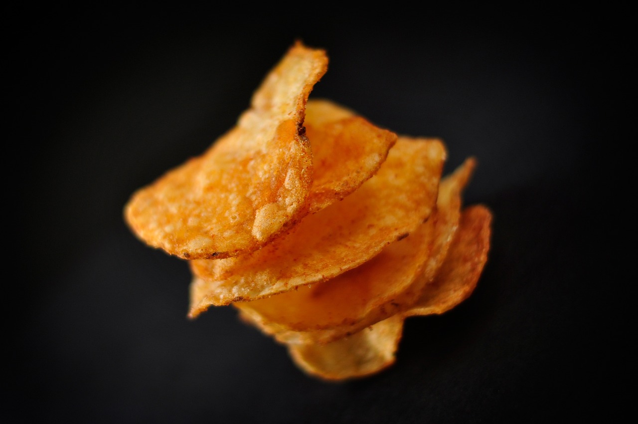 a pile of crisped potato chips on a black surface, inspired by Chippy, one tomato slice, profile shot, an orange, subtle detailing