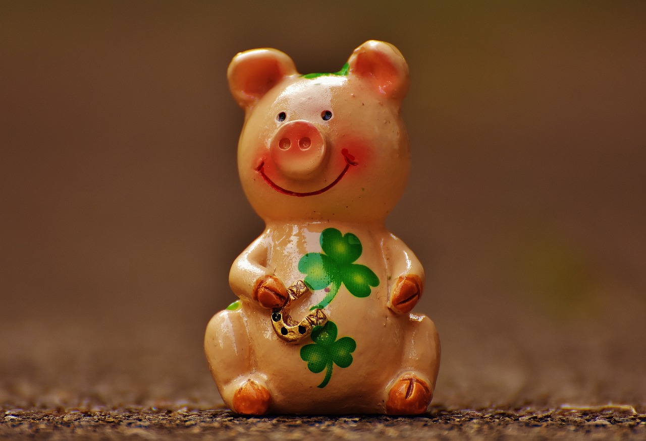 a close up of a figurine of a pig, a photo, by Maksimilijan Vanka, trending on pixabay, background full of lucky clovers, tan, tocchini, smile