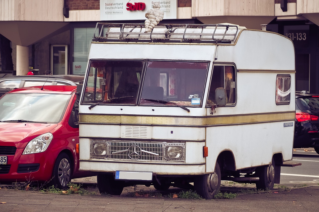 a small white truck parked next to a red car, unsplash, renaissance, a ghetto in germany, rv, car made of meat, zdislav beksinsk - h768