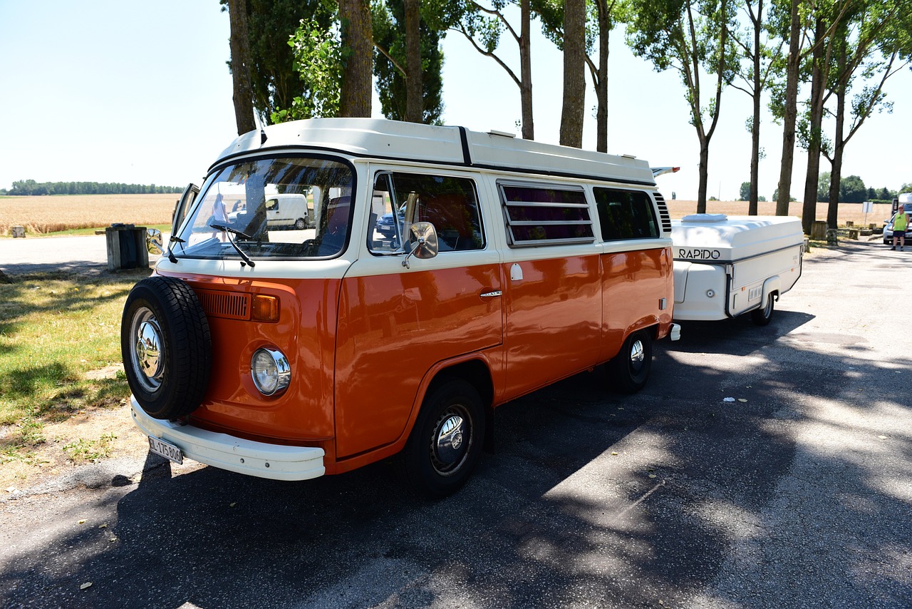 an orange and white van parked on the side of the road, pixabay, retrofuturism, camping, tournament, traveling in france, smokey
