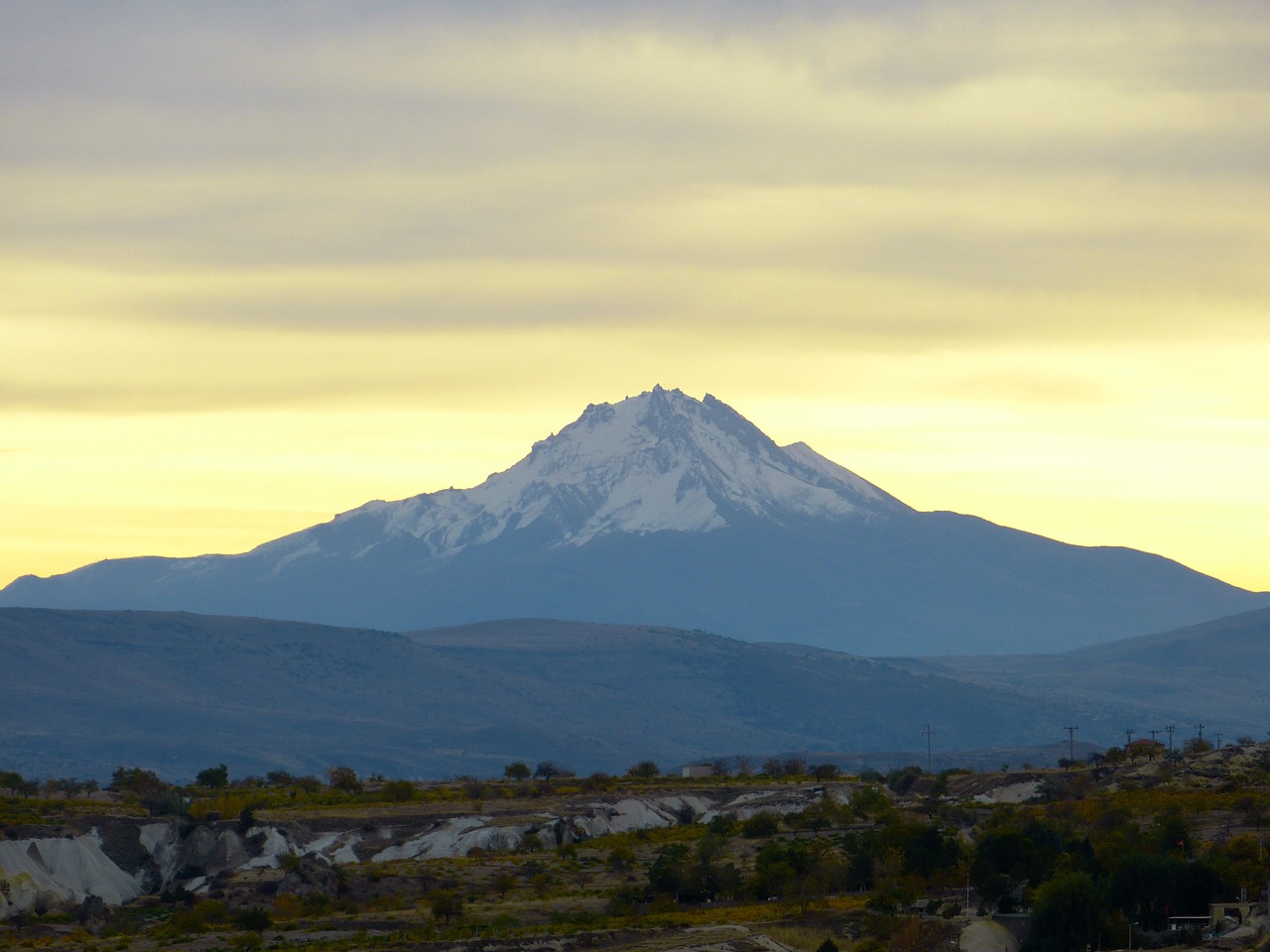 there is a snow covered mountain in the distance, flickr, hurufiyya, beautiful late afternoon, with snow on its peak, in chuquicamata, washington