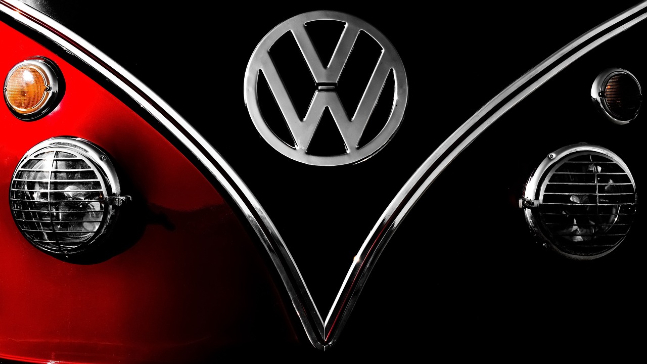 the front end of a red and black vw bus, a picture, by Adam Chmielowski, fine art, banner, chrome art, touareg, emblem