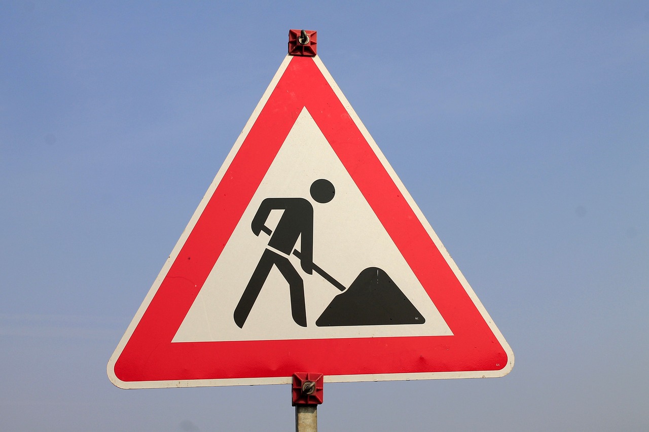 a red and white road sign sitting on top of a pole, pixabay, constructivism, using a spade, wearing hi vis clothing, wielding, stew