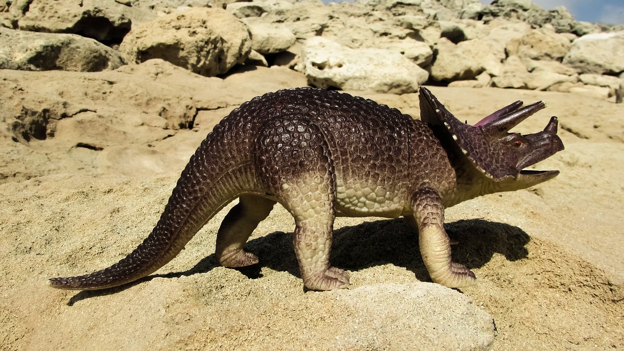 a close up of a toy dinosaur on a rock, by Harold von Schmidt, shutterstock, large horned tail, ”ultra realistic, kangaroo, 1992