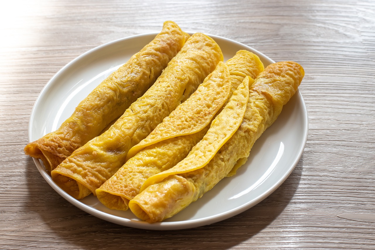 three omelets on a white plate on a wooden table, a stock photo, inspired by Géza Dósa, chinese, pancakes, high detail product photo, yellow