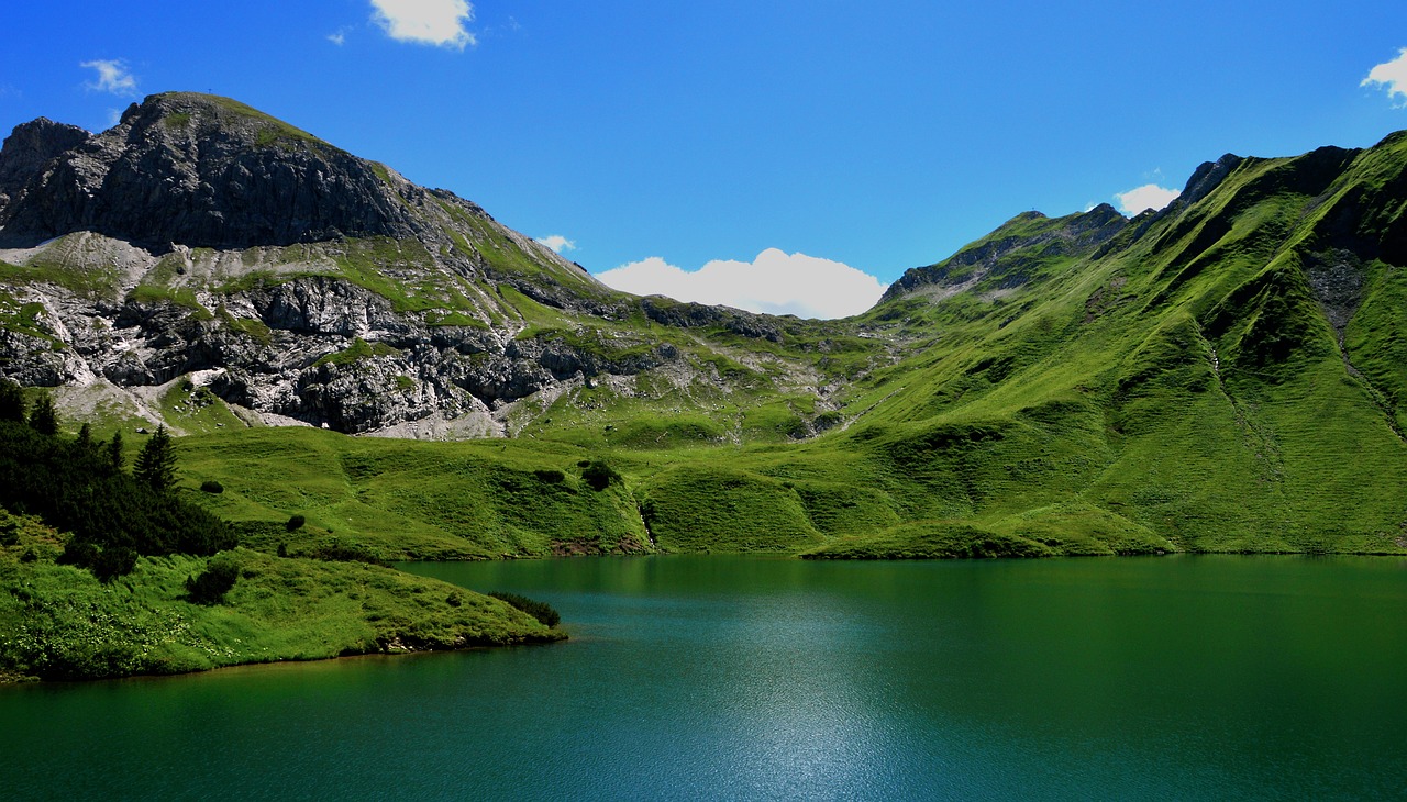 a large body of water surrounded by mountains, by Werner Andermatt, pexels, les nabis, shades of green, fonte à la cire perdue, !!natural beauty!!, fey