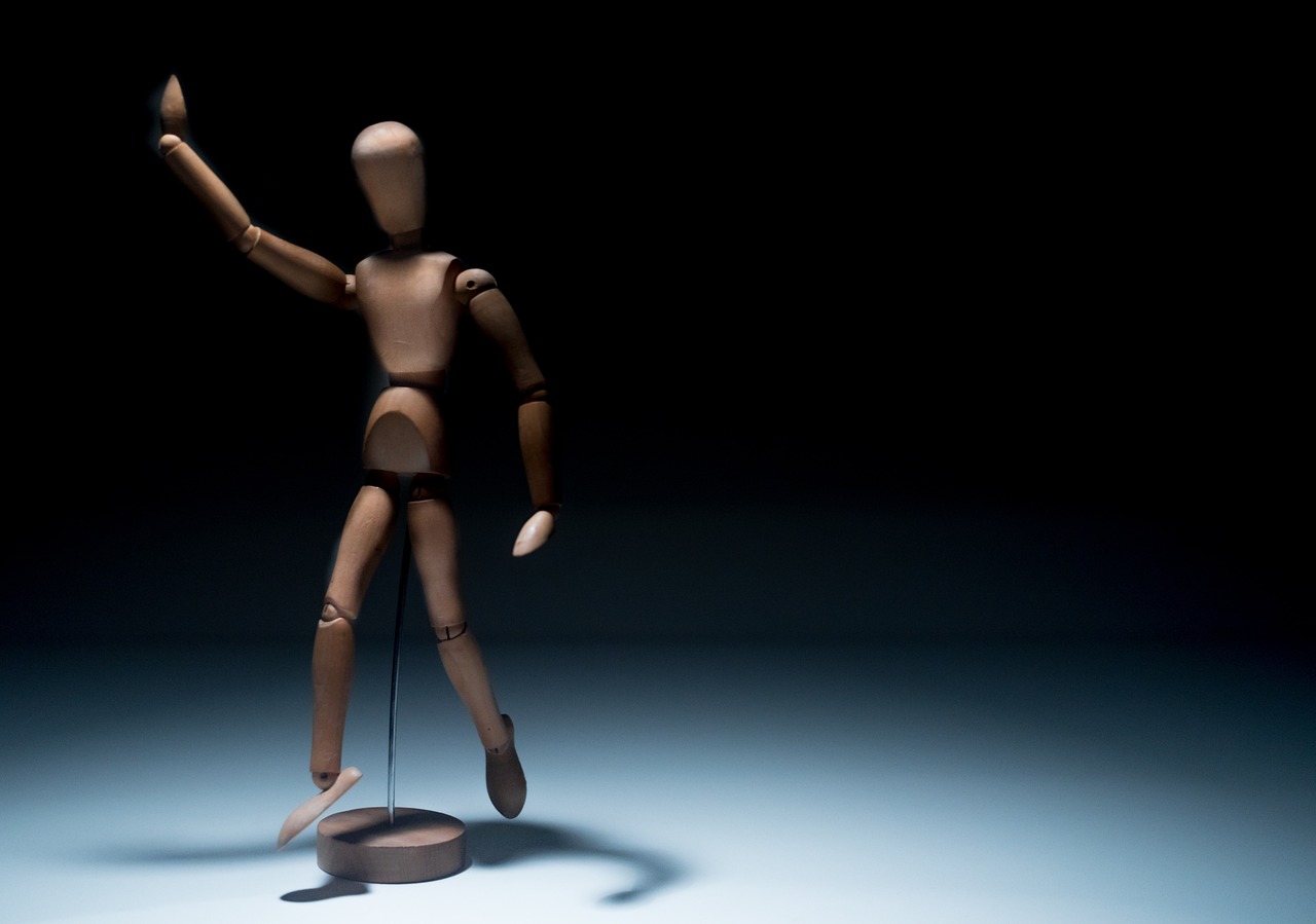 a wooden mannequin standing on a stand in the dark, kinetic art, random positions floating, toy photo, istockphoto, 2 arms and 2 legs!