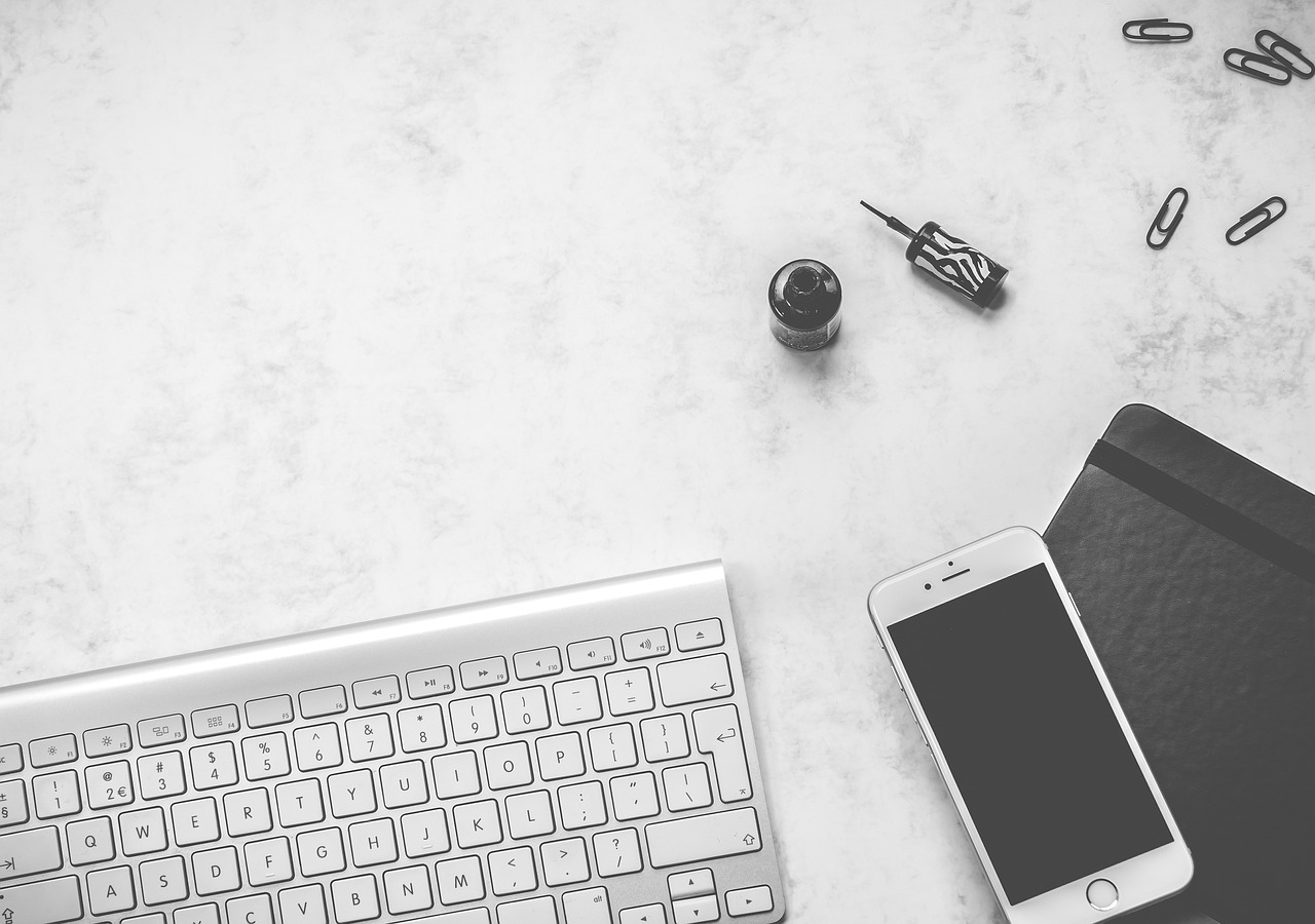 a cell phone sitting on top of a desk next to a keyboard, a picture, pexels, minimalism, black and white palette, carrara marble, background image, white background”