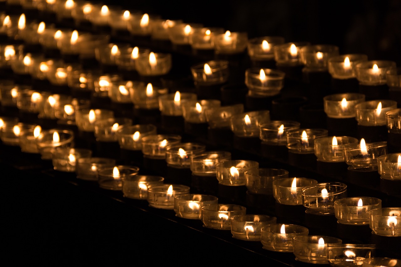 a row of lit candles sitting on top of a table, a picture, by Bernard Meninsky, lines of lights, with a black dark background, holy, the photo shows a large