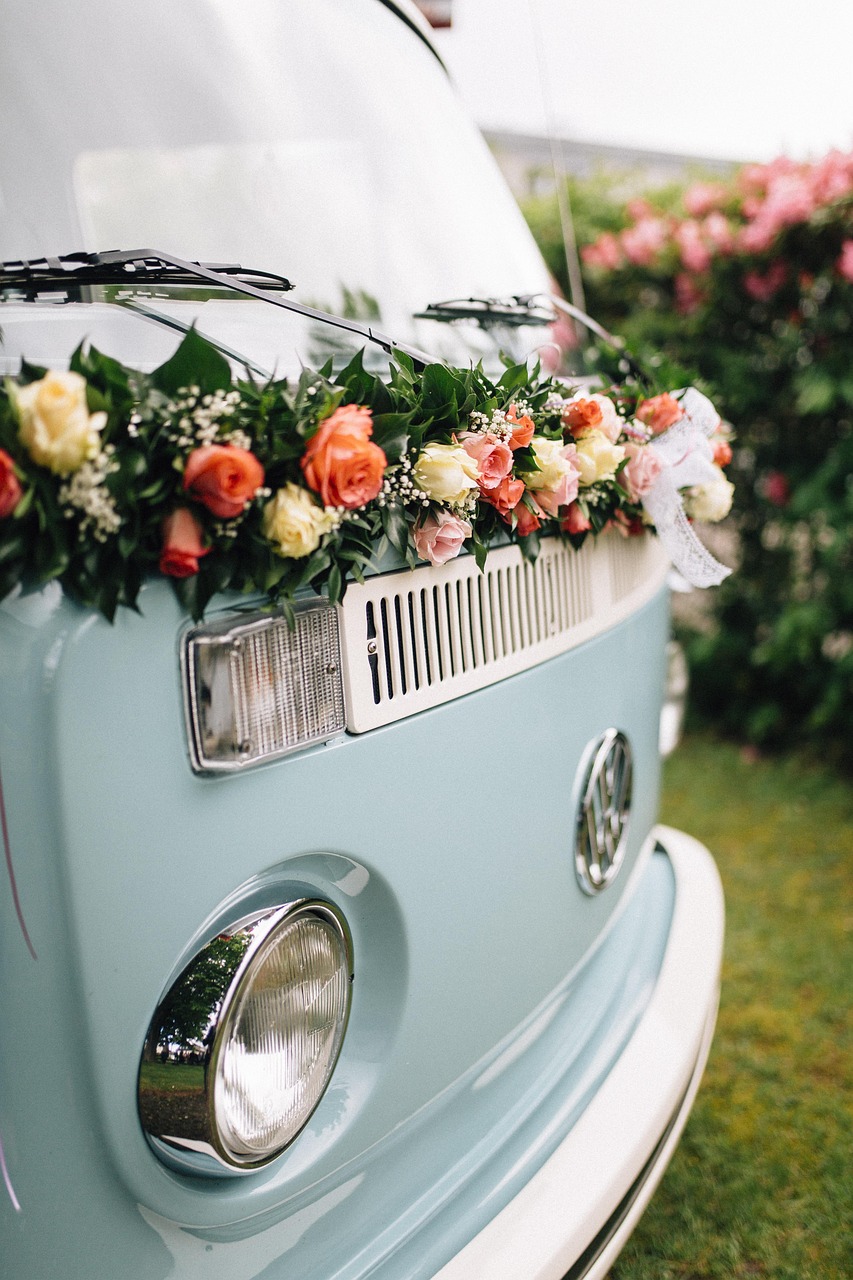 a blue vw bus decorated with flowers and greenery, teal and orange colour palette, pastel tone, vintage theme, midsommar color theme