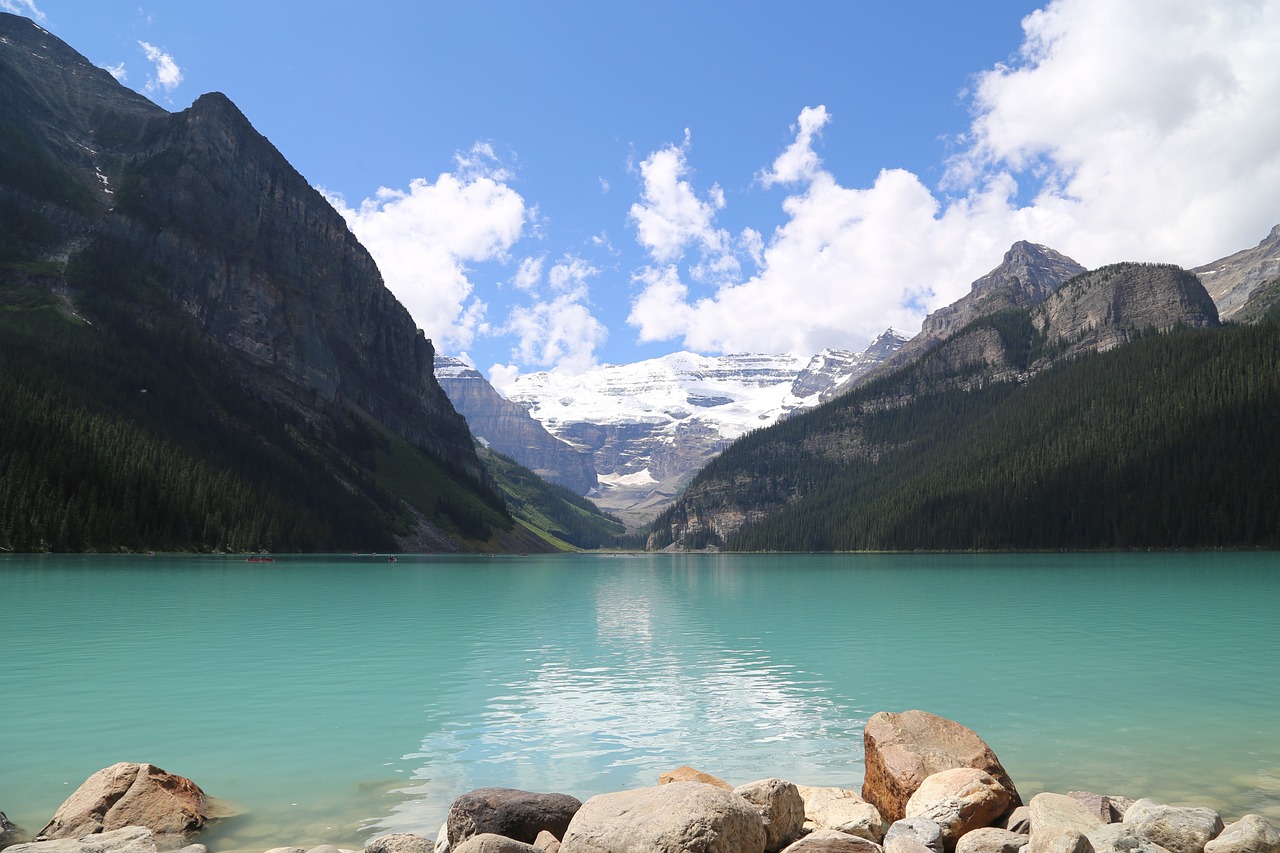 a large body of water surrounded by mountains, a picture, by Brigette Barrager, shutterstock, rocky mountains in background, summer day, tiffany, stock photo