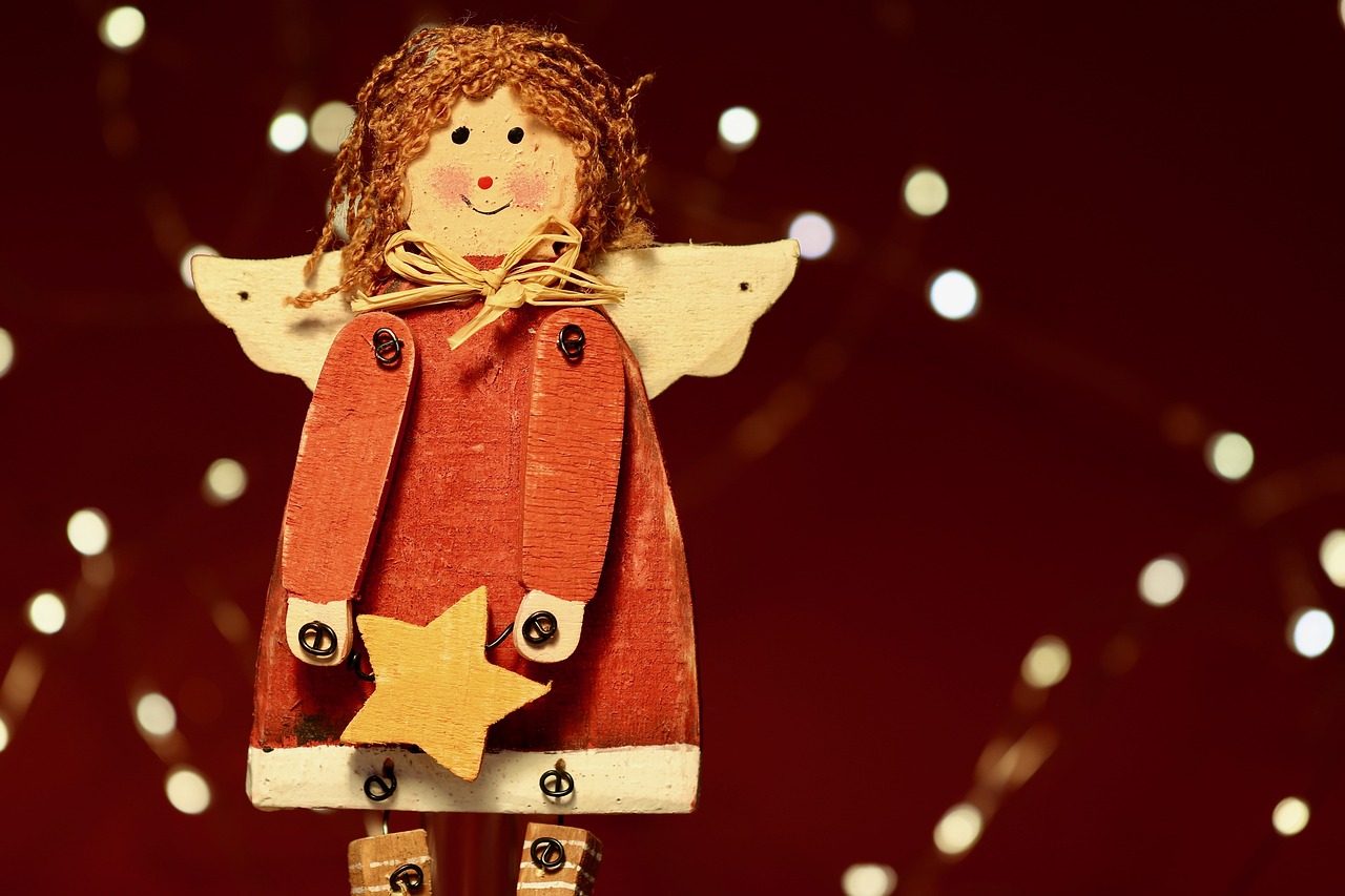 a close up of a wooden toy with lights in the background, a portrait, folk art, of beautiful angel, red and brown color scheme, with stars, fully body photo