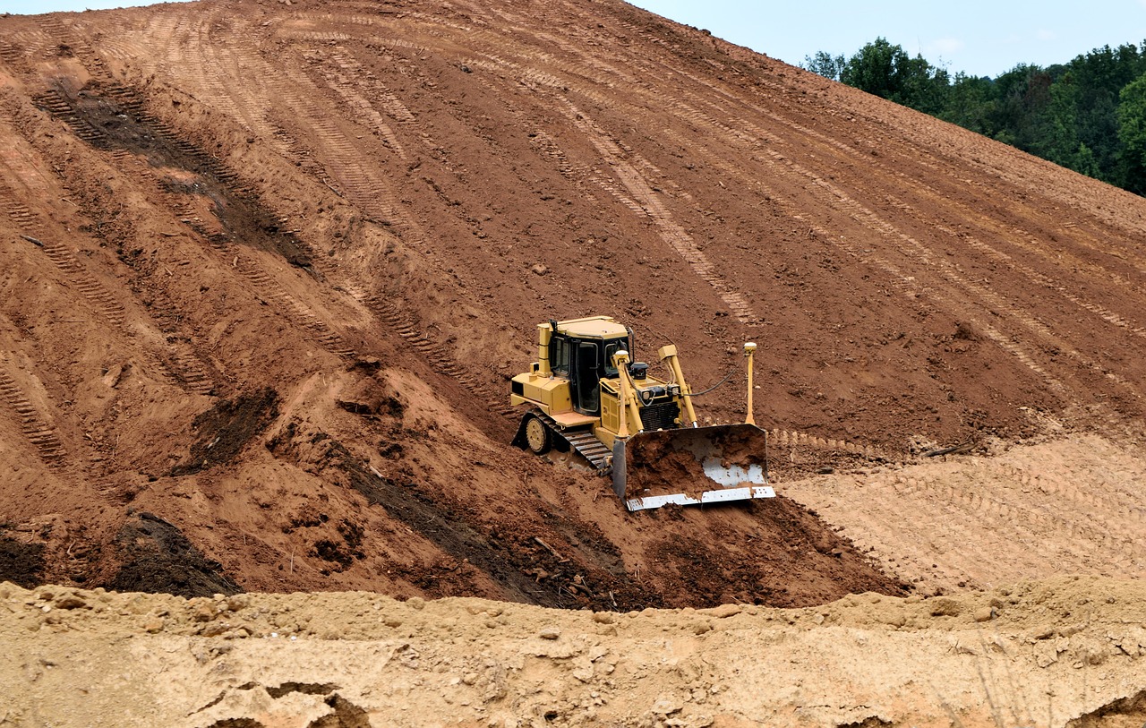 a bulldozer sitting on top of a pile of dirt, a photo, wide shot photo, high res photo