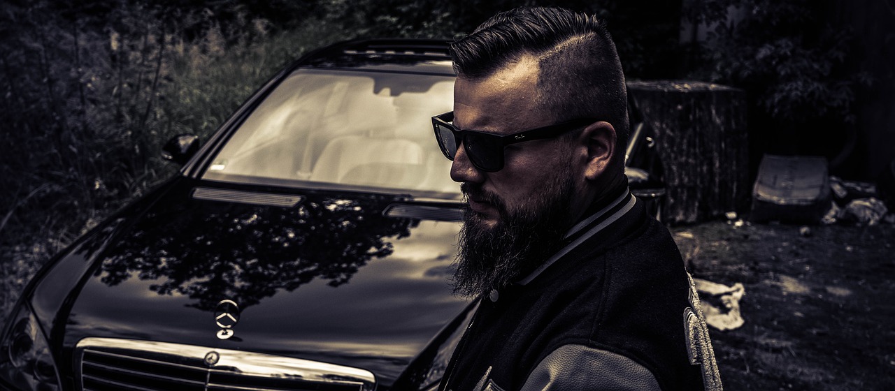 a man with a beard standing in front of a car, by Adam Szentpétery, purism, portrait of ernest khalimov, profile picture 1024px, biker, with sunglass