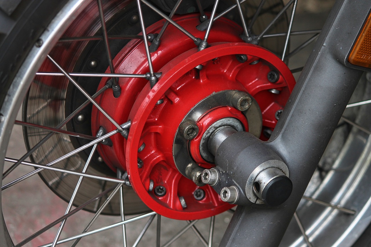 a close up of a red wheel on a motorcycle, a picture, flickr, assemblage, deep shafts, colored accurately, maintenance, forbearing
