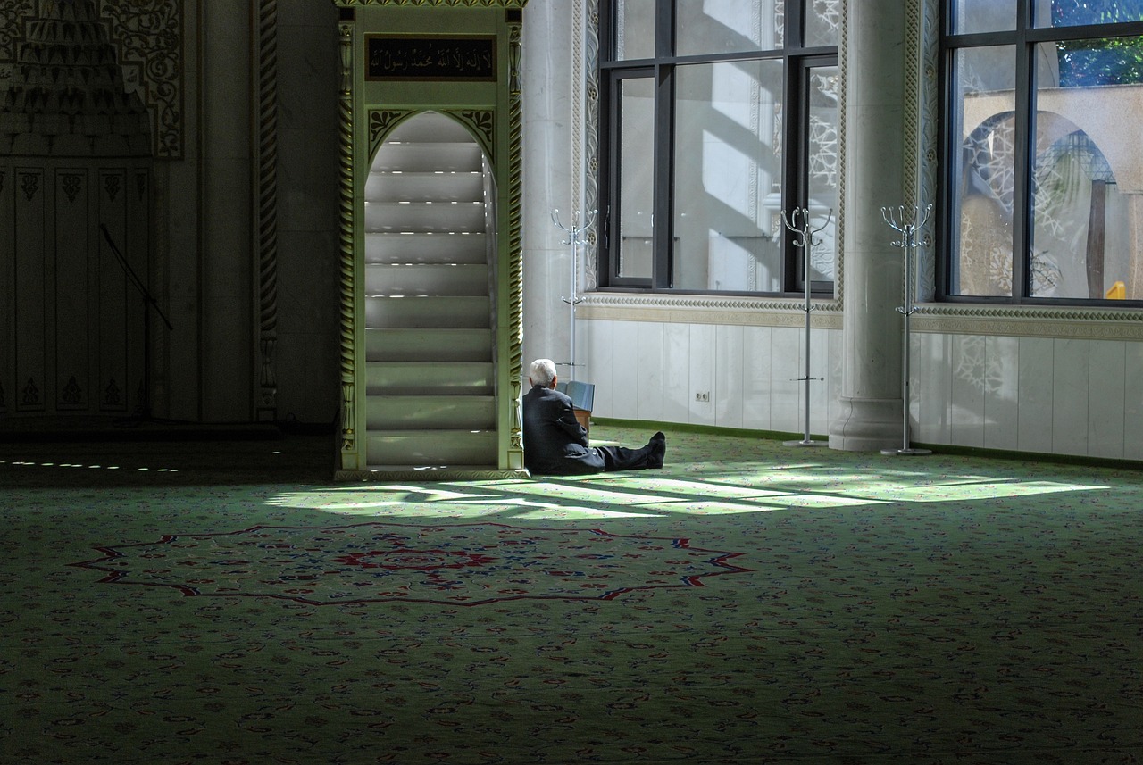 a man sitting on the floor using a laptop, a photo, inspired by Ibrahim Kodra, flickr, hurufiyya, cybermosque interior, ray of light through white hair, paris 2010, carpet