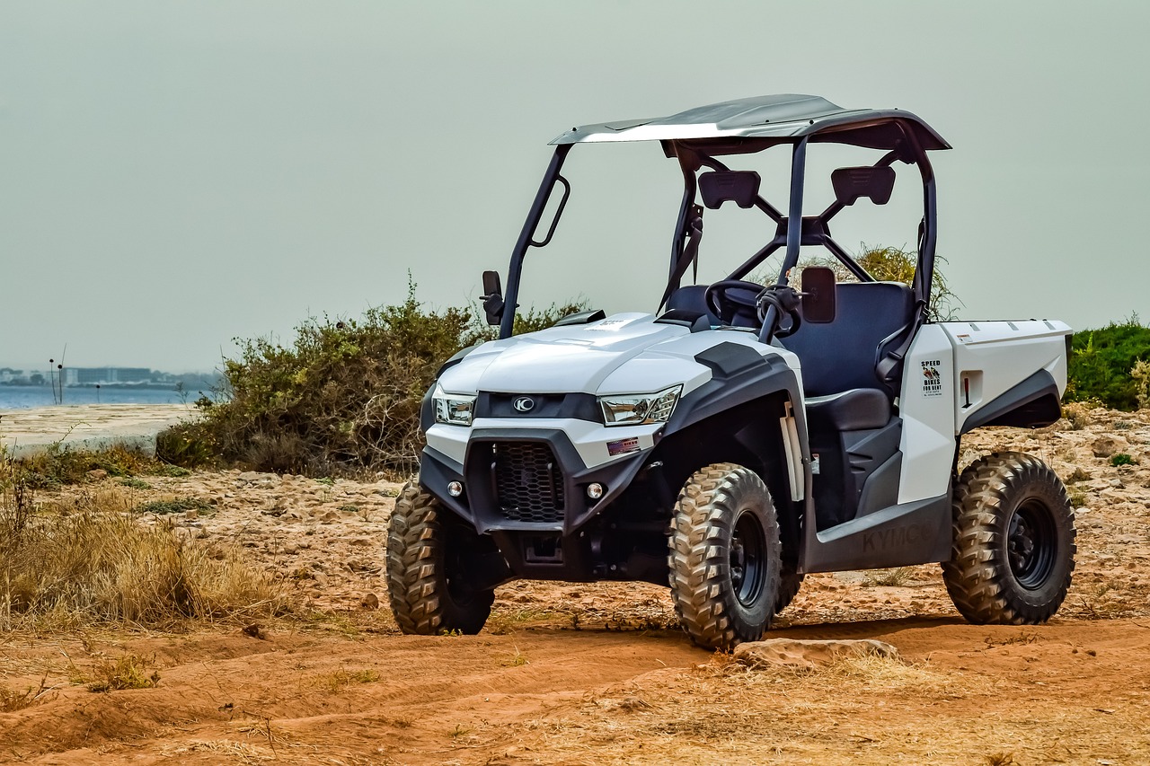 a silver and black utility vehicle on a dirt road, cobra, clean and pristine design, optimus sun orientation, grey metal body, high quality product image”