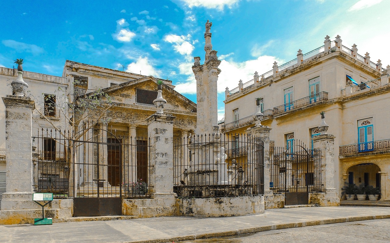 a large building with a clock tower in front of it, by Juan Giménez, shutterstock, neoclassicism, old cemetery, cuban setting, roman bath, marbled columns