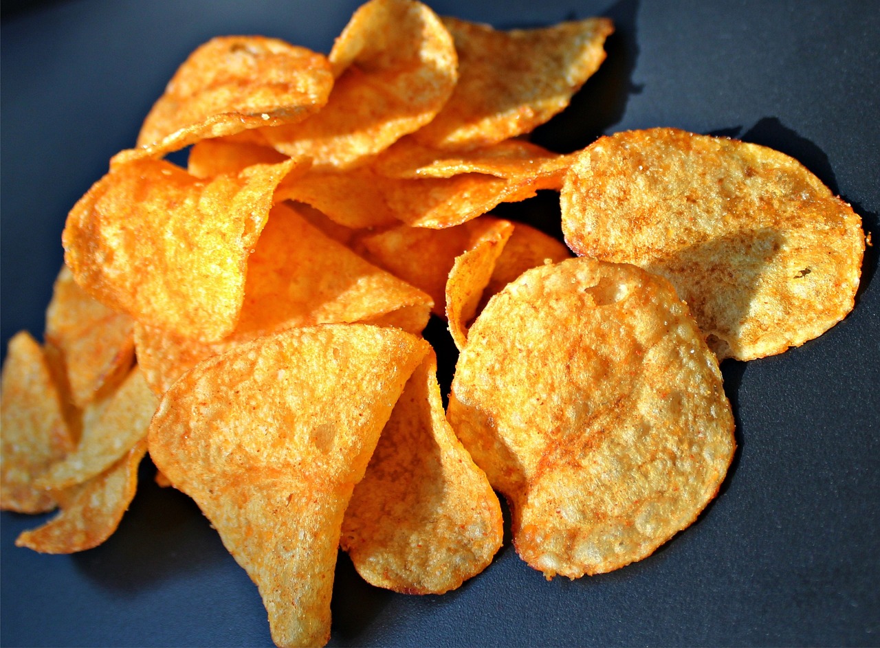 a pile of potato chips sitting on top of a table, inspired by Chippy, pixabay, photorealism, pepperoni, soft shade, view from bottom to top, looking across the shoulder
