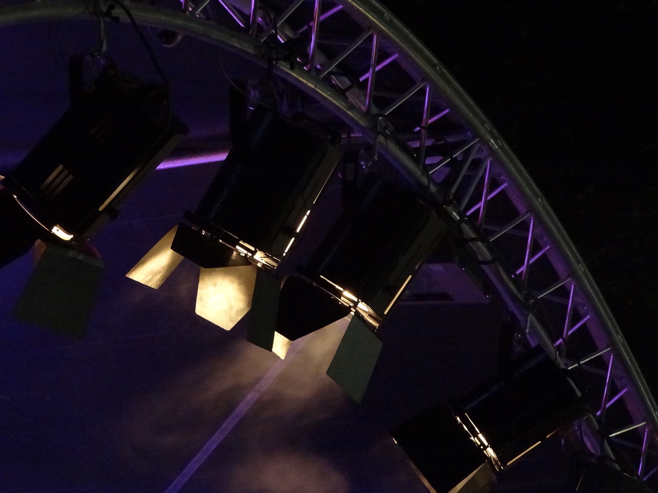 a group of lights hanging from the side of a ferris wheel, by Werner Gutzeit, flickr, kinetic art, stage speakers, curved. studio lighting, horns with indicator lights, cool purple slate blue lighting