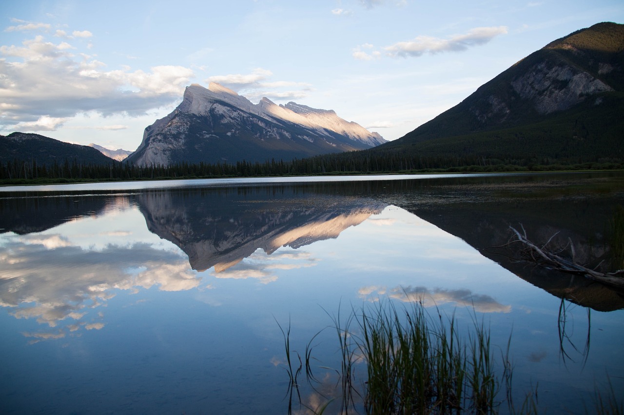a body of water with a mountain in the background, a picture, by Brigette Barrager, smooth reflections, banff national park, sweeping landscape, summer evening