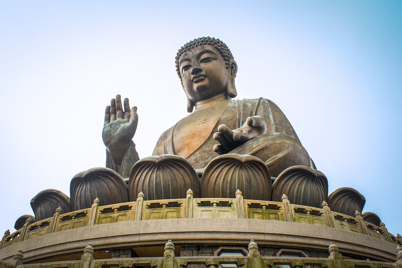 a large statue of buddha sitting on top of a building, by Matt Stewart, pexels, cloisonnism, sits on a finger, 🚿🗝📝