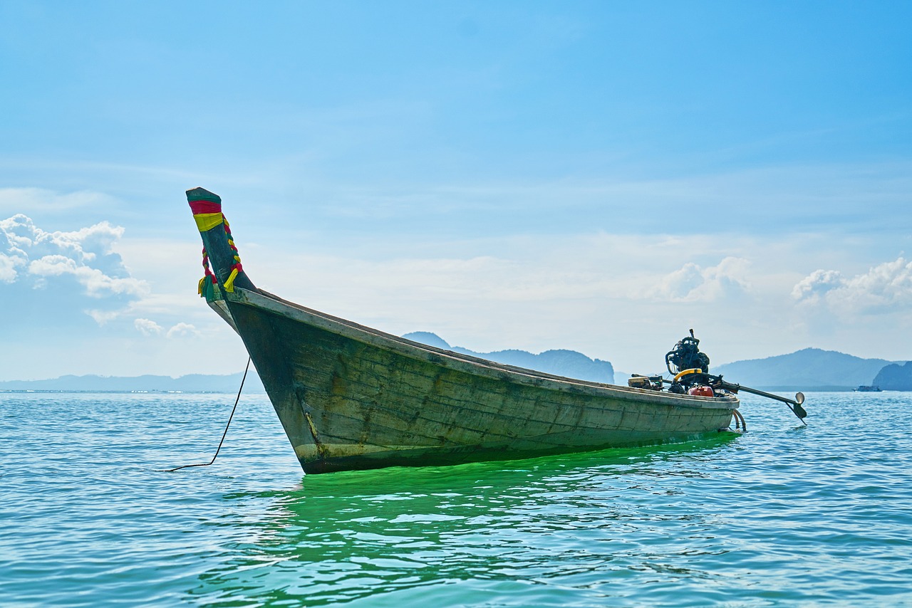 a boat floating on top of a body of water, a picture, by Richard Carline, shutterstock, south east asian with long, rasta, navy, stock photo