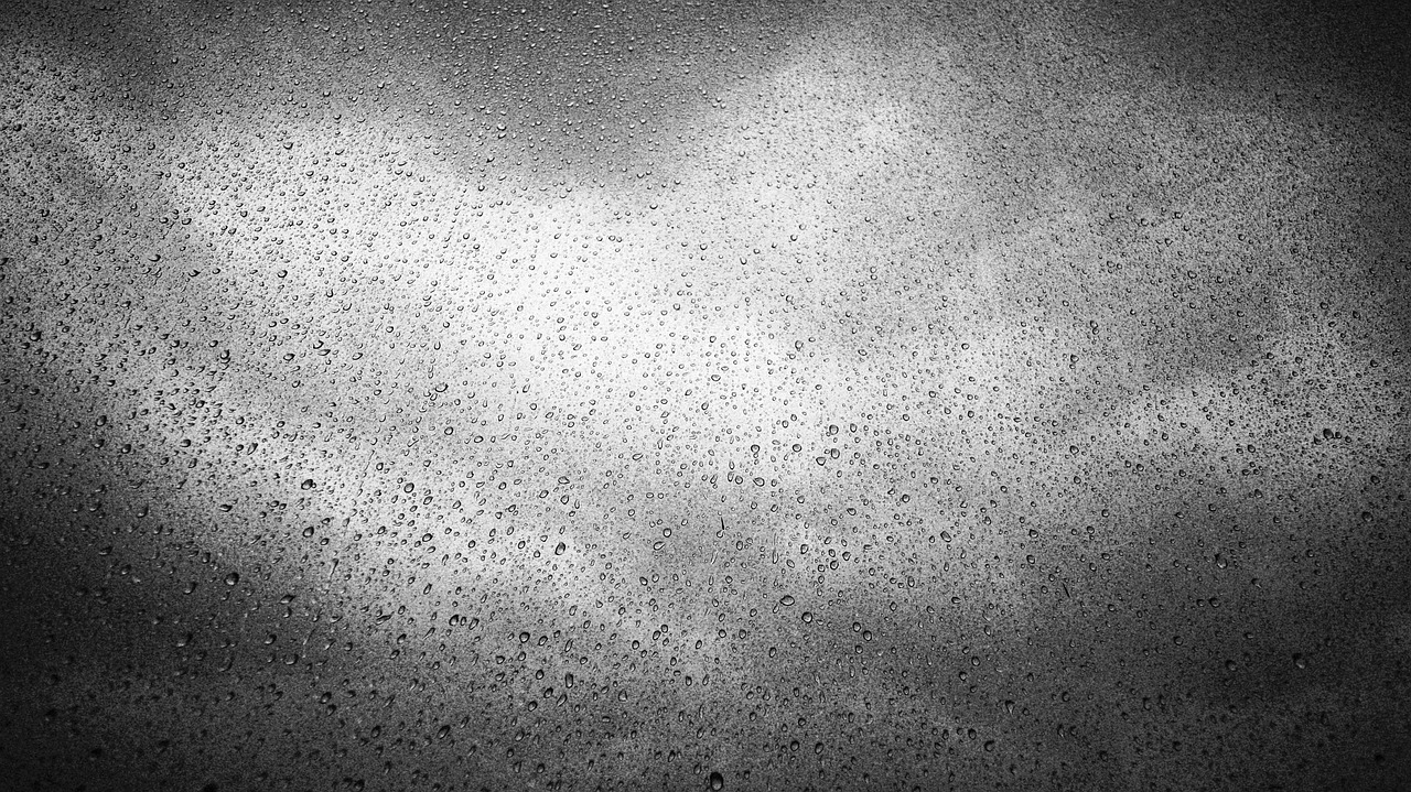 a black and white photo of a cloudy sky, inspired by Jan Rustem, pexels, minimalism, covered in water drops, 1 9 7 0 s car window closeup, metal texture, surface with beer-texture