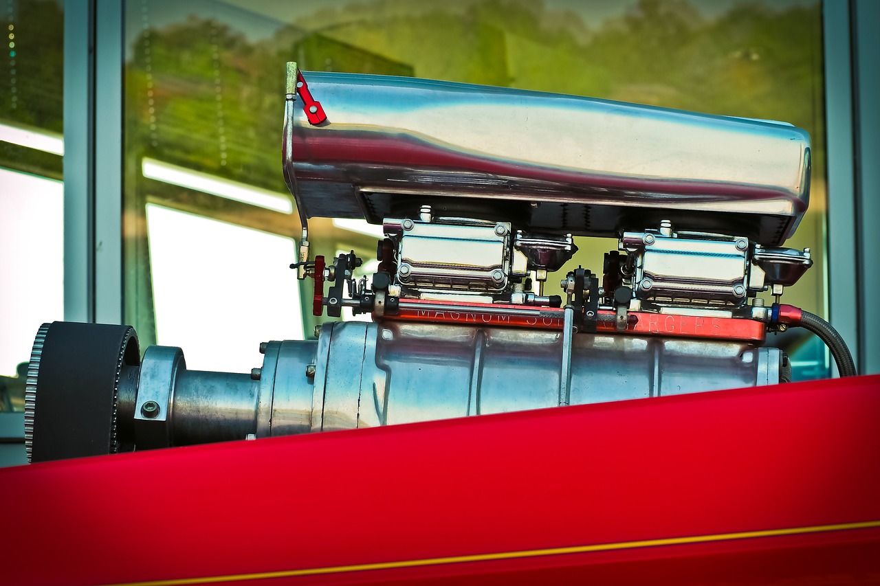 a close up of an engine on a red car, by Wayne England, precisionism, with big chrome tubes, vintage color, trailer, high speed