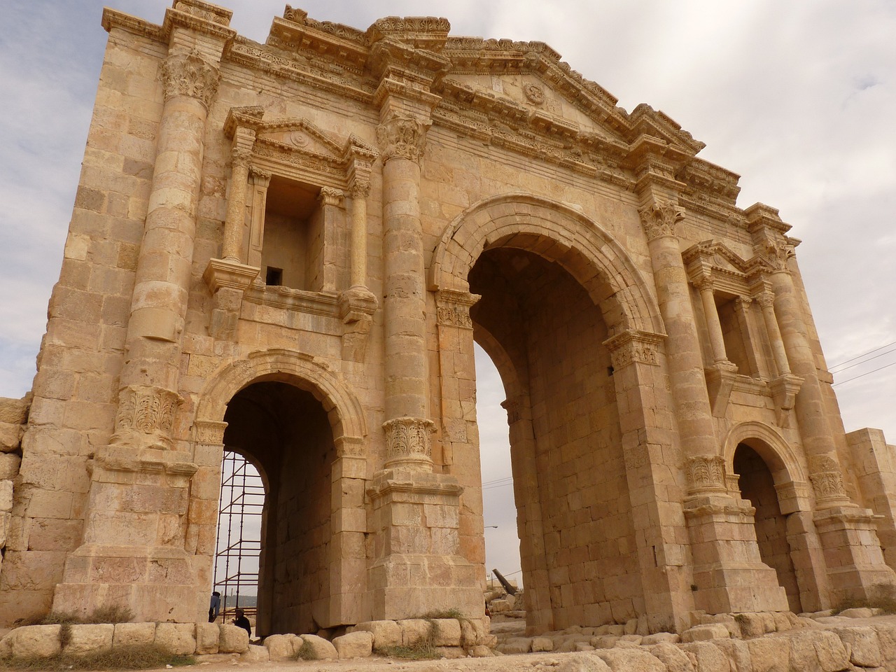 a man standing in front of a stone arch, by Steven Belledin, flickr, neoclassicism, jordan, khedival opera house, huge giant old ruins, seen from outside