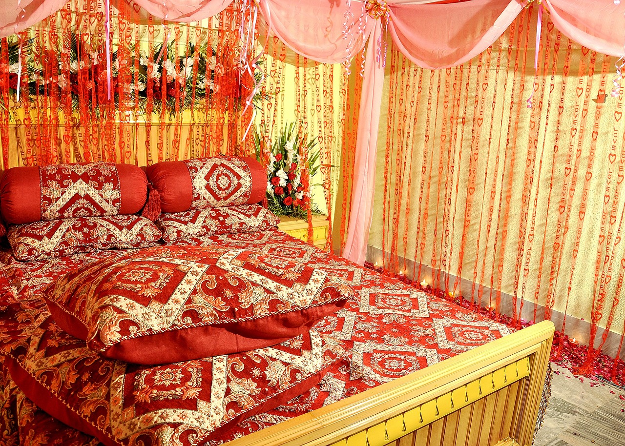 a bed room with a neatly made bed and curtains, by Ambreen Butt, flickr, red and gold cloth, wedding, colorful”, but very good looking”