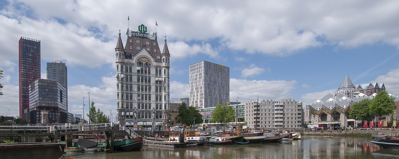 a bunch of boats that are in the water, a photo, by Peter Wtewael, pixabay, art nouveau, brutalist buildings tower over, maurits cornelis, wikimedia commons, seen from outside