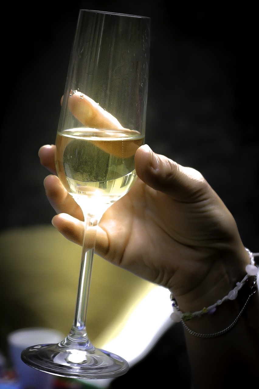 a person holding a glass of wine in their hand, by Jan Rustem, afp, white wine bottle, photograph credit: ap, digital photo