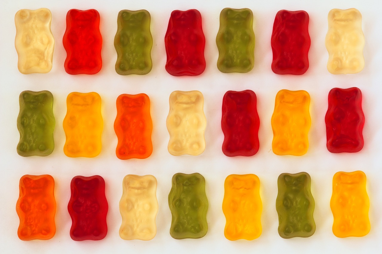 a number of gummy bears on a white surface, a picture, inspired by Fernando Botero, bauhaus, mid-twenties, kodak photo