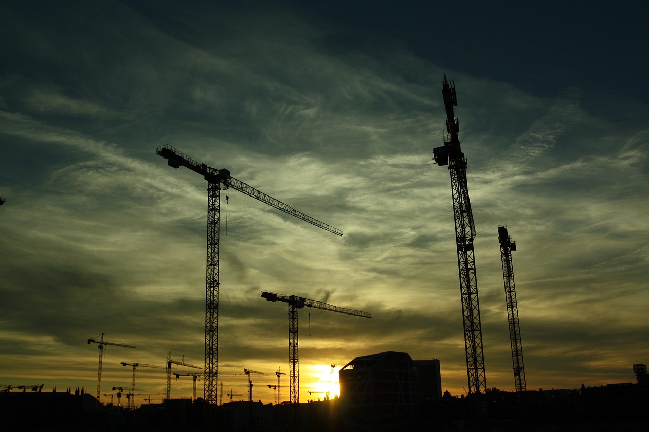 a group of cranes are silhouetted against the setting sun, by Mathias Kollros, flickr, constructivism, [ [ hyperrealistic ] ], under construction, jcb, a green