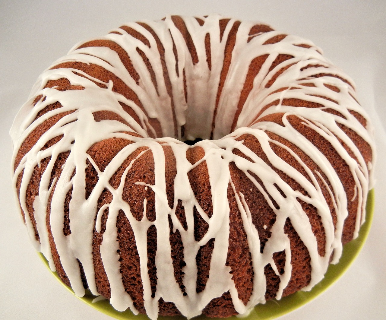 a bundt cake with white icing on a plate, by Carey Morris, flickr, full of greenish liquid, extremely detailed frontal angle, birch, zulu