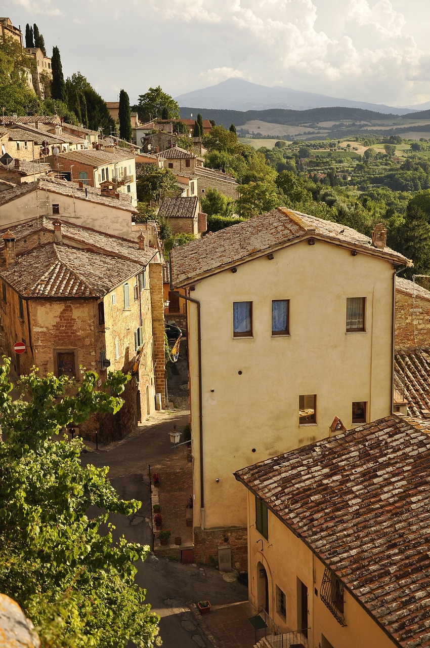a view of a town from the top of a hill, a picture, by Carlo Martini, shutterstock, sienna, quaint village, late afternoon light, streetscape
