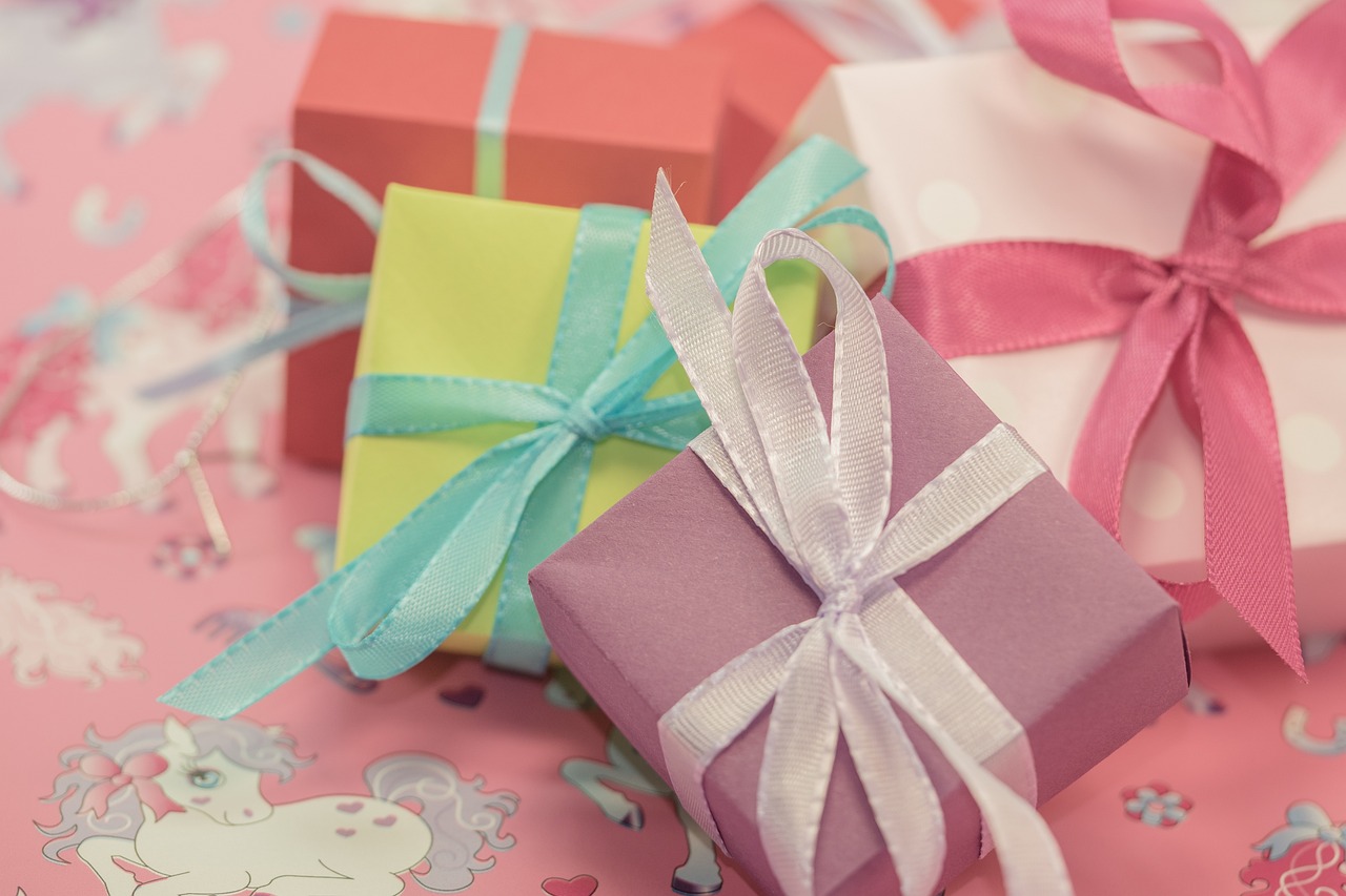 a couple of gift boxes sitting on top of a table, by Rhea Carmi, pixabay, lots of pastel colour, 🎀 🗡 🍓 🧚, ribbon, close up photograph