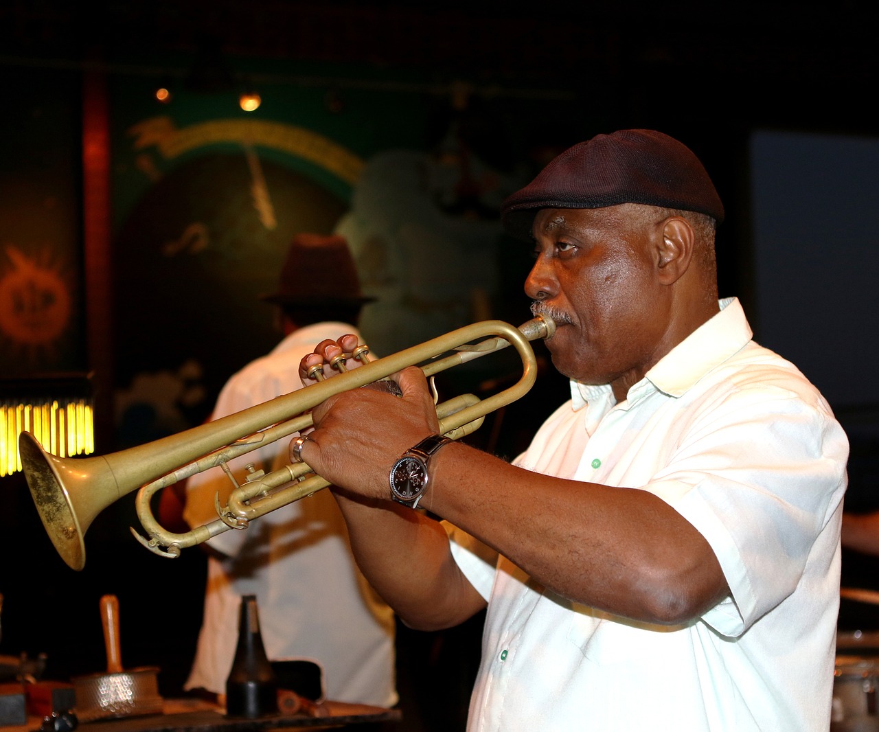 a man playing a trumpet in a bar, flickr, atiba jefferson, he is about 7 0 years old, stock photo, performing on stage
