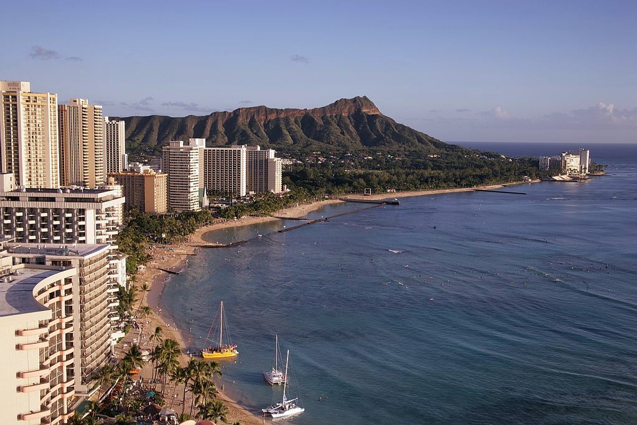 a large body of water surrounded by tall buildings, a photo, pixabay, plein air, hawaii beach, mountains and ocean, high definition screenshot, festival