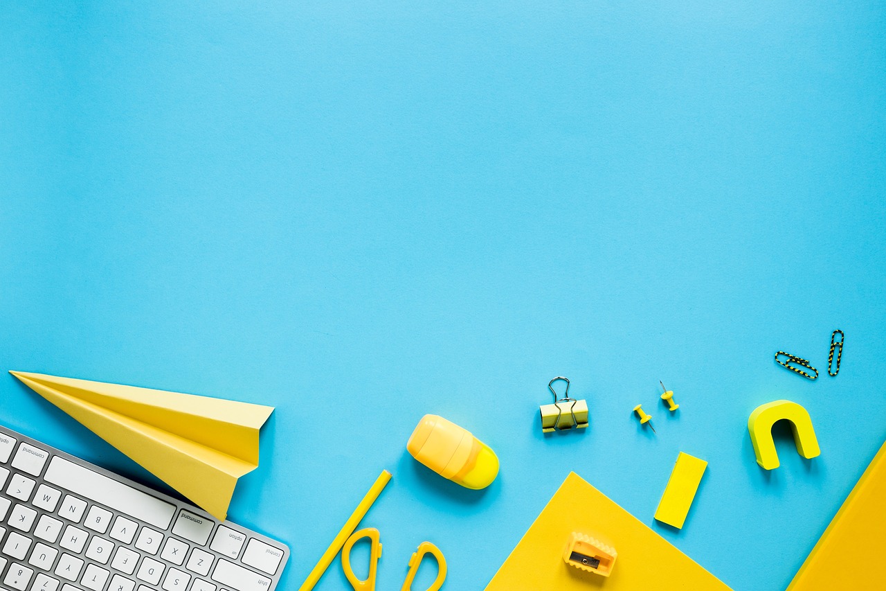 a computer keyboard sitting on top of a desk, a stock photo, yellow and cyan color palette, paper airplane, teacher, playful composition canon
