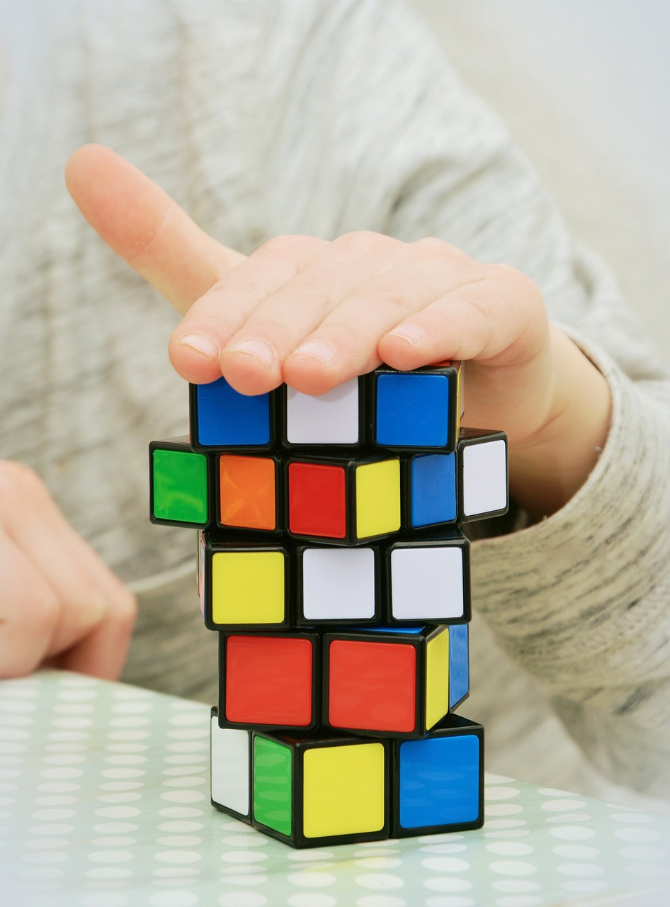 a close up of a person holding a rubik cube, a picture, cubo-futurism, jenga tower, closeup photo, little kid, with index finger