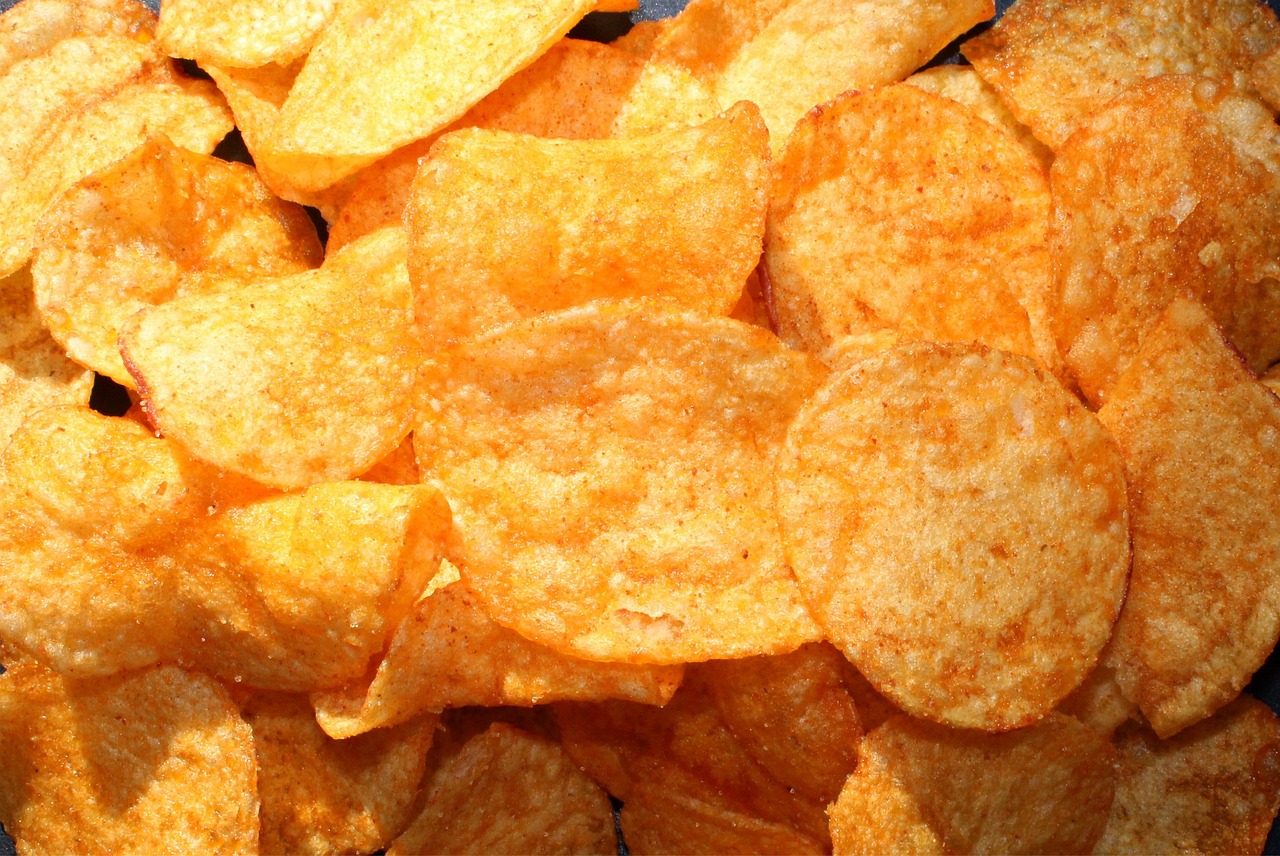 a pile of potato chips sitting on top of a table, a macro photograph, inspired by Chippy, pexels, photorealism, very orange, pepperoni, screengrab, bottom view ， bladerunner