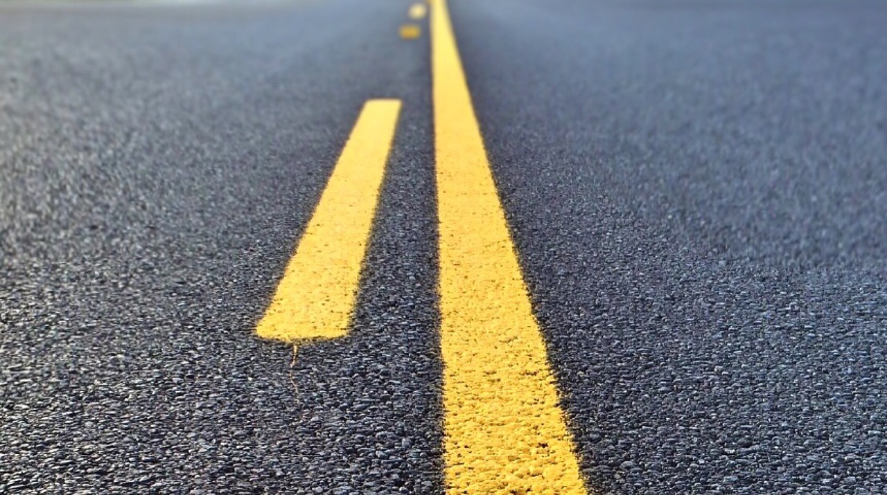 a yellow line in the middle of a road, zoomed in, edited, photo taken with provia, mid closeup