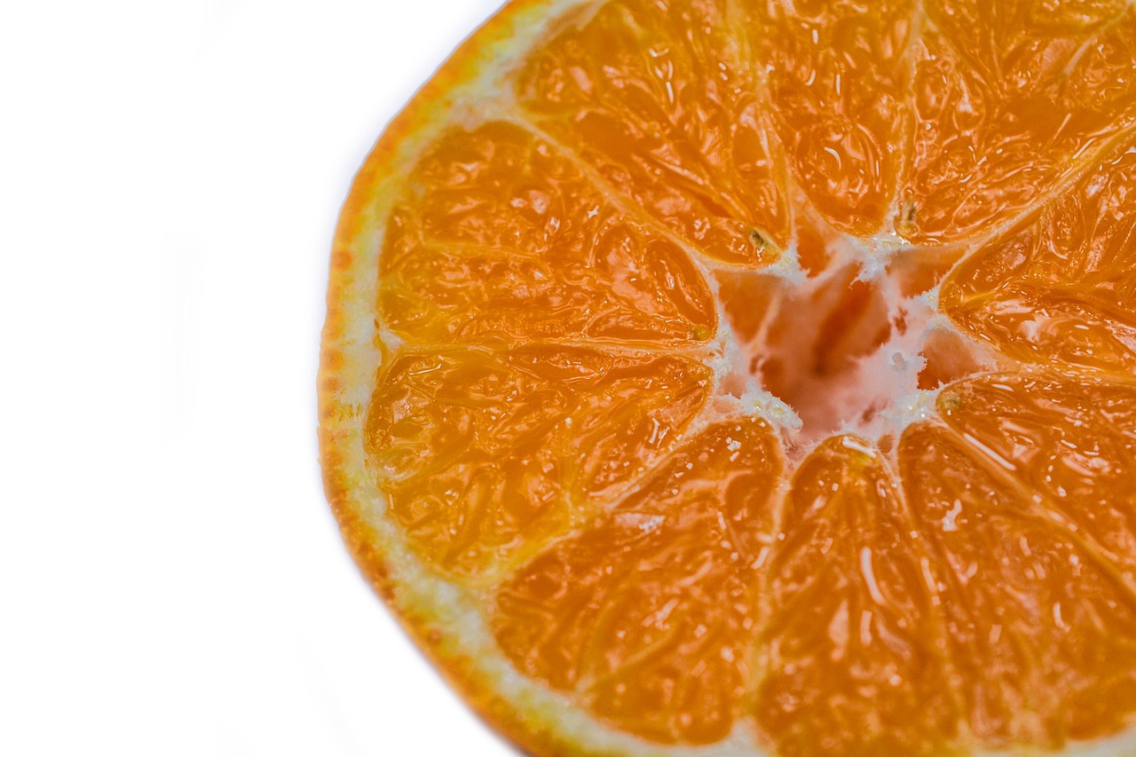 an orange cut in half on a white surface, a macro photograph, minimalism, modern high sharpness photo