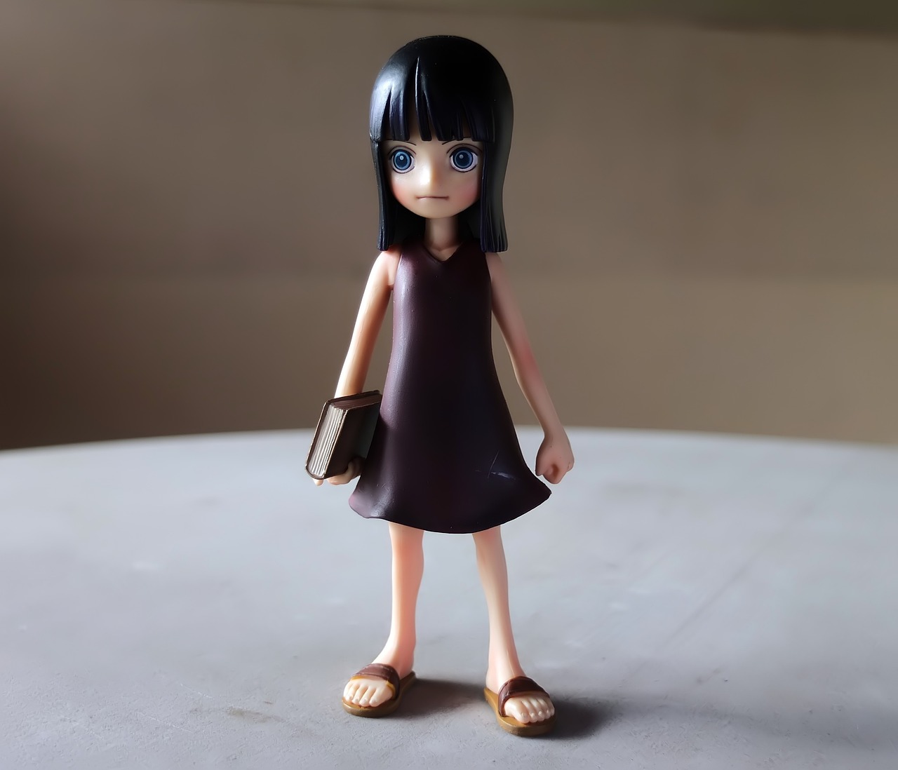 a close up of a doll on a table, a picture, inspired by Eiichiro Oda, fullbody photo, airbrush dark dress, with straight black hair, full body photo