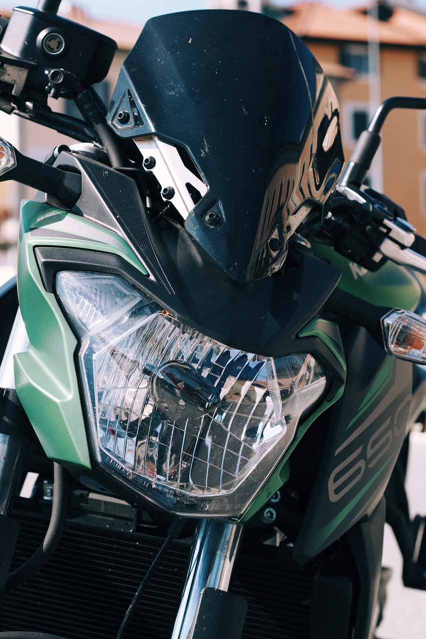 a green motorcycle parked on the side of the road, by Matija Jama, pexels contest winner, photorealism, uhd face details, front light, green facemask, front of car angle