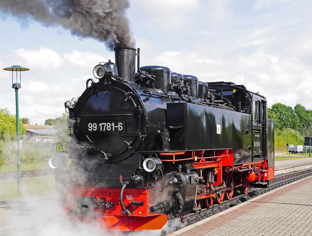 a black and red train traveling down train tracks, by Jörg Immendorff, shutterstock, steam engine, preserved historical, on a bright day, zdislav beksinsk - h768